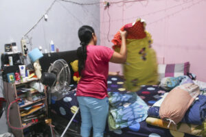 Domestic worker makes a bed and does laundry in Indonesia