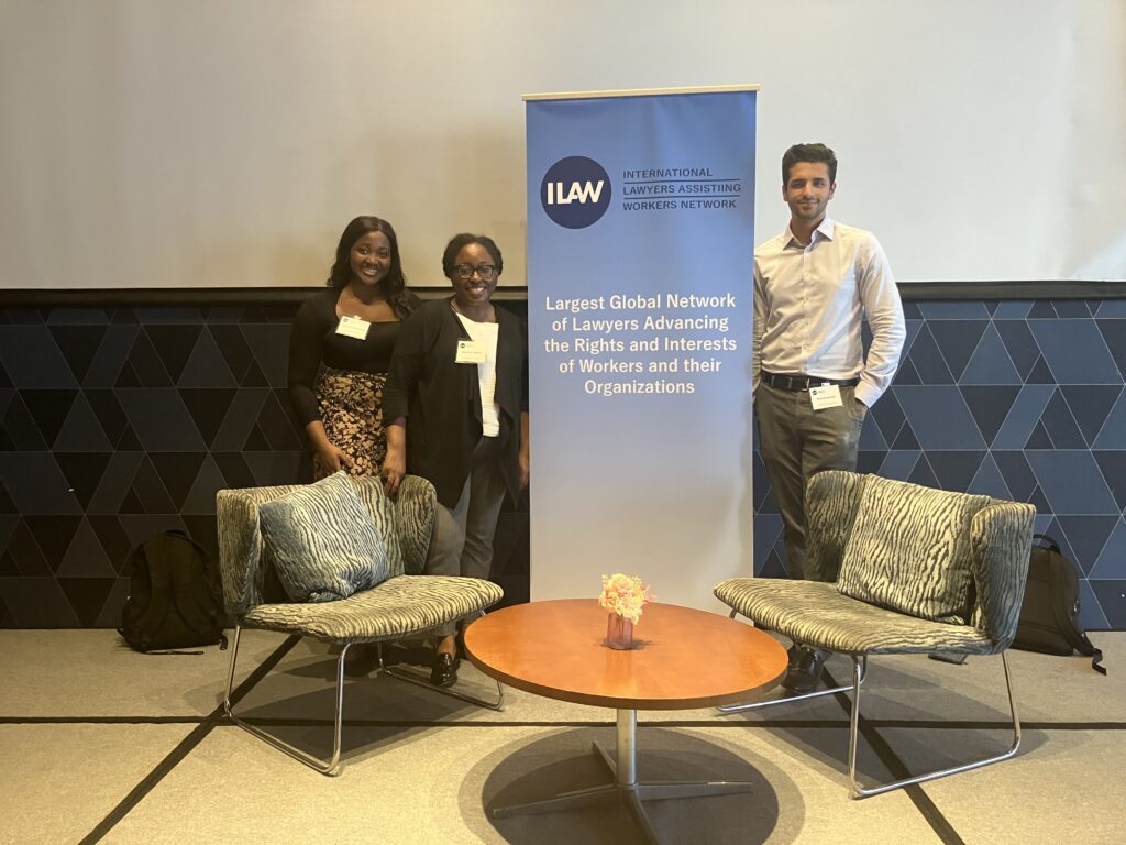 Clinician and two students stand in front of conference banner